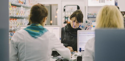 A woman purchasing medicine at a pharmacy